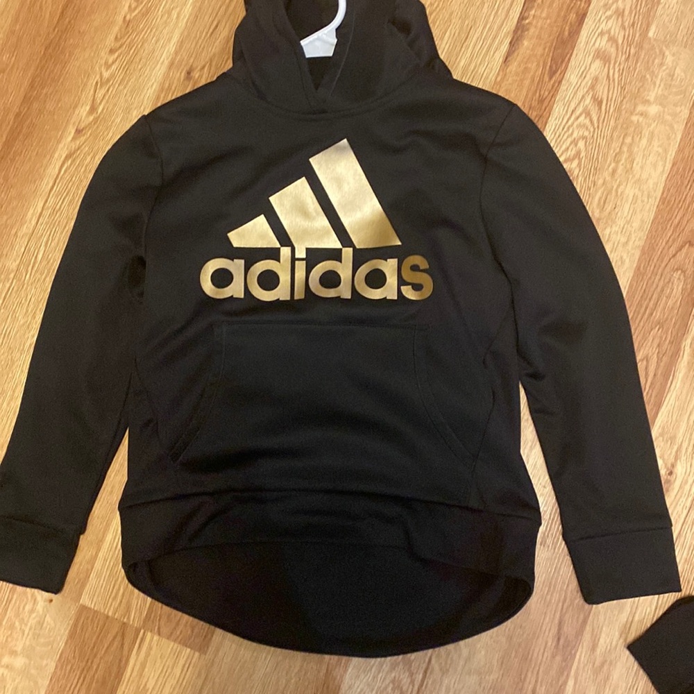 Black adidas hoodie with gold writing lightly worn size 14 from “Adidas”.